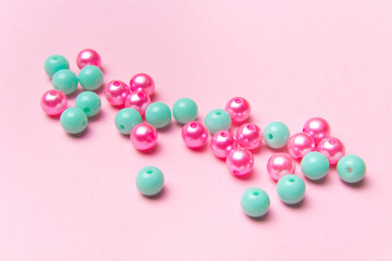 The concept of order and chaos. Chaotic disorganized colorful beads on pink background