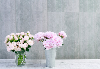 Pink peonies and roses on grey stone background