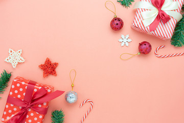 Table top view of Merry Christmas decorations & Happy new year ornaments concept.Flat lay essential difference objects gift box & fir tree on modern pink paper background at home studio office desk.