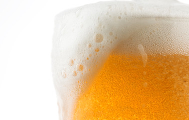 Closeup of a glass of beer with foaming bubbles.