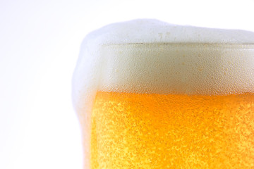 Pouring beer with bubble froth in glass on withe background.