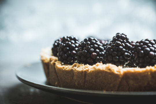 Fresh blackberry cheesecake on the rustic background. Selective focus. Shallow depth of field.