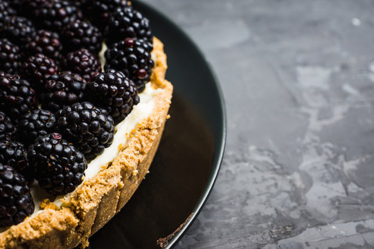 Fresh blackberry cheesecake on the rustic background. Selective focus. Shallow depth of field.