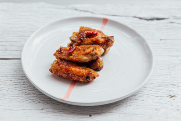 Korean Chicken Wings stir with Korean style sauce served in white plate. 