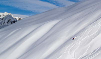 winter mountain landscape with snow and mountains with a skier