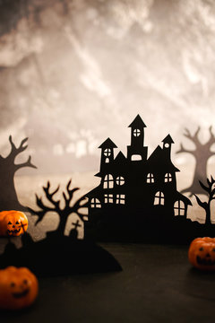 Halloween night background. Paper art. Abandoned village in a dark misty forest