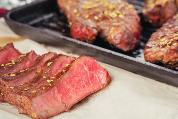 Close up of sliced grilled steak on frying pan