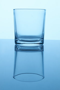Empty glass cup. Close up. Reflective surface.