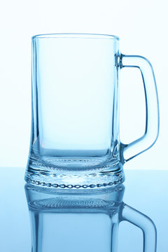 Empty beer glass mug, close up. White isolated background. Blue lighting.
