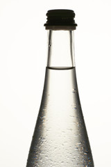 Bottleneck of glass bottle close up. Water drops. Isolated on white.