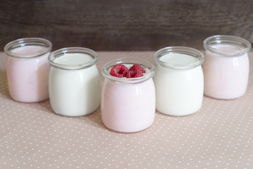 Obraz na płótnie Canvas yogurt jars and fresh raspberries