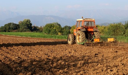 Tractor with a towed plow completes the plowing of the field before the autumn sowing