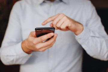 close up of man using smartphone. concept of phone addiction. young business man typing and browsing social media on his phone. 