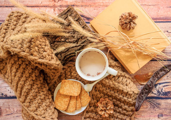 Autumn composition.Cones, books,scarf,log tree, cup and cookies on a wooden background