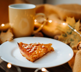 Pumpkin pie, tart made for Thanksgiving day with nuts on a white plate.Wood background Top view