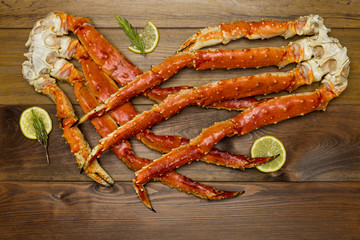 Crab claws with lemon on wooden background