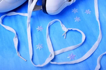 Keuken spatwand met foto White figure skate shoelaces forming a heart against the blue background © kcuxen