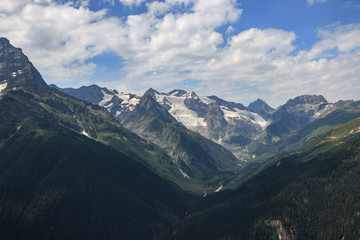Naklejka premium Closeup view mountains scenes in national park Dombai, Caucasus, Russia, Europe. Summer landscape, sunshine weather, dramatic blue sky and sunny day