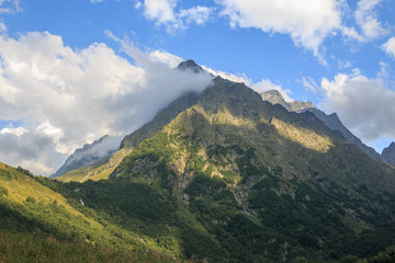 Fototapeta na wymiar Closeup view mountains scenes in national park Dombai, Caucasus, Russia, Europe. Summer landscape, sunshine weather, dramatic blue sky and sunny day