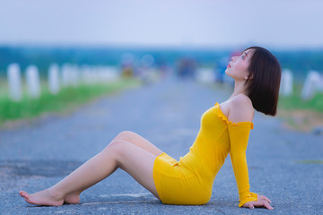Portrait of beautiful asian woman wear yellow dress at the field,Thailand people