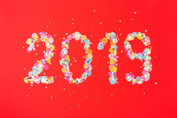 2019 New Year card. Red holiday background with confetti.