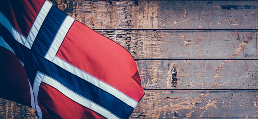 Banner with waving Norwegian flag on the old wooden pattern background with copy space