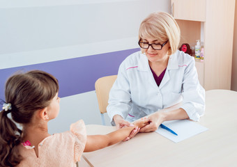 Pediatrician measuring girl’s heart rate