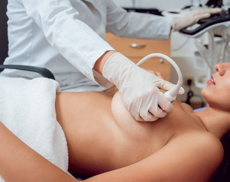 Gynecologist performing breast examination for her patient using ultrasound scanner. Sonography. Medical equipment healthcare. Ultrasound scanning.