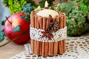 Candle decorated with cinnamon sticks
