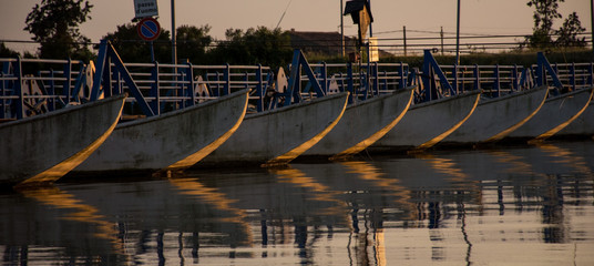 Porticciolo al tramonto con le barche attraccate indorate dalla luce del sole che scende