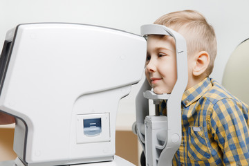 Ophthalmologist woman doctor examining vision of little child in clinic