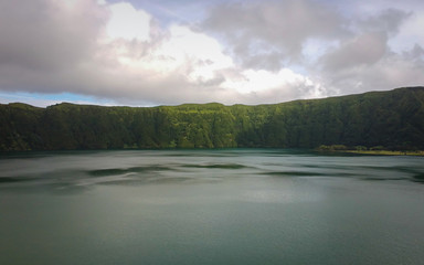 Fototapeta premium Aerial View from a beautiful lagoon surrounded by mountains. Ancient volcano crater. Seven Cities lagoon Azores Islands Portugal