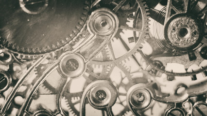 Black and white grunge sepia background with vintage clock mechanism texture. concept of transferring hours to winter time or summer time, selective focus.