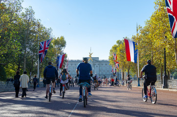 Cyclists on the Mall with British and Dutch flags in autumn, London, England