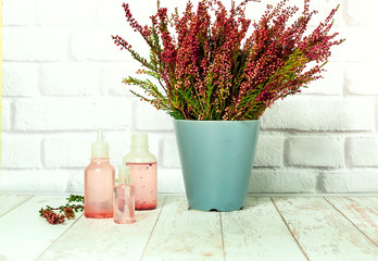 Bouquet of heather and tincture of heather flowers on light background, the concept of healing plants, close up,copy space