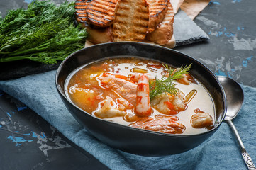 French fish soup Bouillabaisse with seafood, salmon fillet, shrimp, rich flavor, delicious dinner. Close up - obrazy, fototapety, plakaty