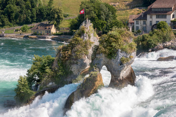 Fototapeta premium The Rhine Falls is the largest waterfall in Europe in Schaffhausen, Switzerland. Summer day with sun. View from castle Laufen