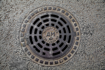 Manhole cover in the road of asphalt