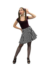 Pin up girl in polka-dot dress, black stockings and in high heels shoes is listening a sounds isolated on the white background.
