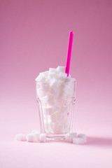 Sugar in glass on on pink background