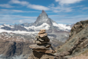 View balance stones, far away Matterhorn mountain, scenes in national park Zermatt, Switzerland, Europe. Summer landscape, sunshine weather, dramatic blue sky and sunny day