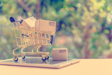 Electronic commerce or eCommerce and online shopping concept : Goods, boxes in a shopping cart on a...