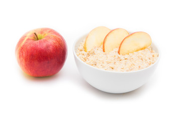 Oatmeal in white bowl and red apple on white background. Isolated on white. Healthy food