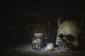 Magic potion and human skull on magic table background. Witchcraft concept.