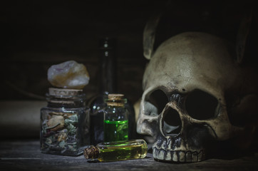 Magic potion and human skull on magic table background. Witchcraft concept.