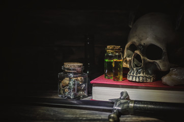 Magic potion, book of magic and human skull on magic table background. Witchcraft concept.