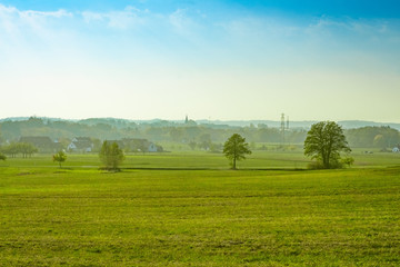 Dorf hinter grüner Wiese und vor blauen Himmel (Ezelsdorf, Mittelfranken)