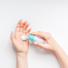 Woman moisturizing her hands with foam lotion