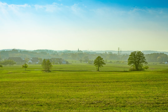 Dorf hinter gr&uuml;ner Wiese und vor blauen Himmel (Ezelsdorf, Mittelfranken)