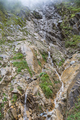 Wasserfall in den Alpen im Nebel